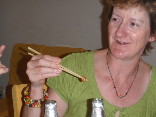 Glenda is demonstrating how to hold two oiled peanuts.
